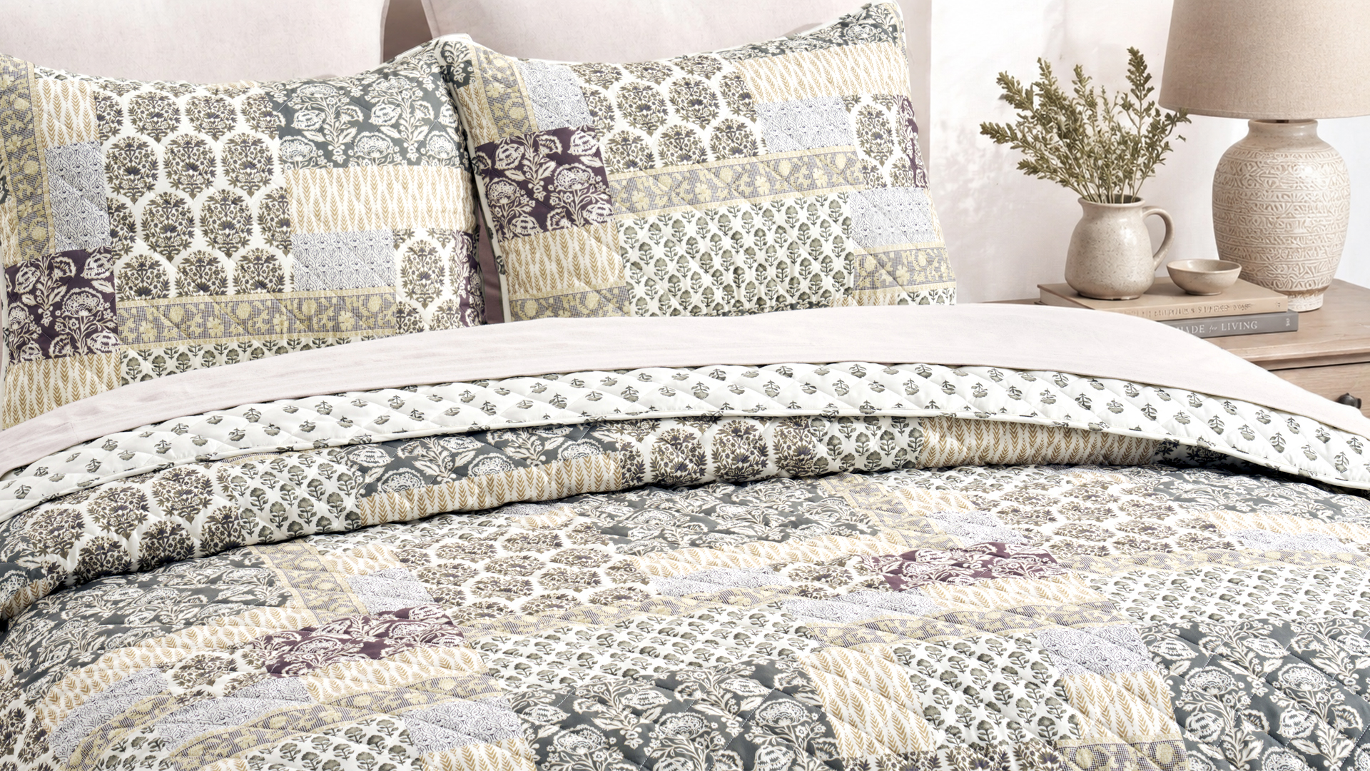 ABS bedding — patchwork quilt set with matching shams beside a nightstand