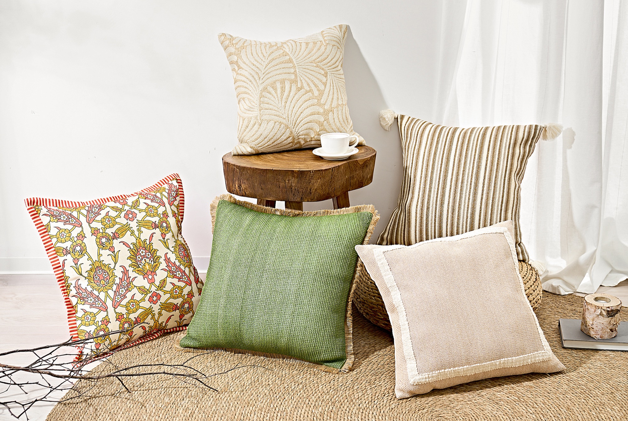 ABS outdoor — patterned outdoor pillows clustered on a jute rug